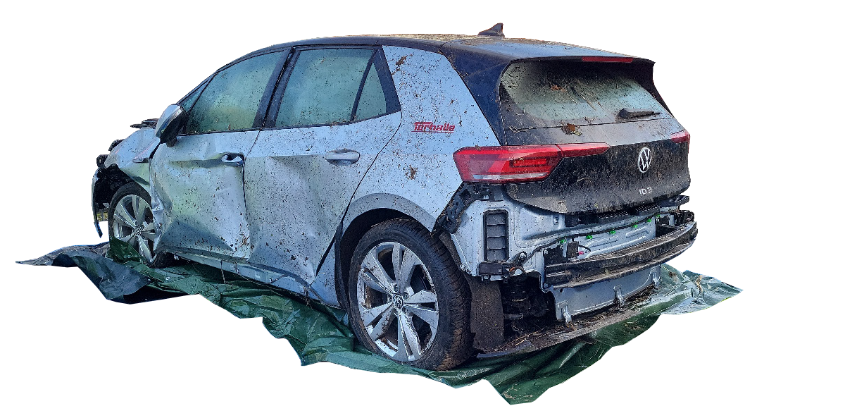 amf-bergung-elektroauto-panne-1 Verunfallter VW auf grüner Decke vor transparentem Hintergrund.