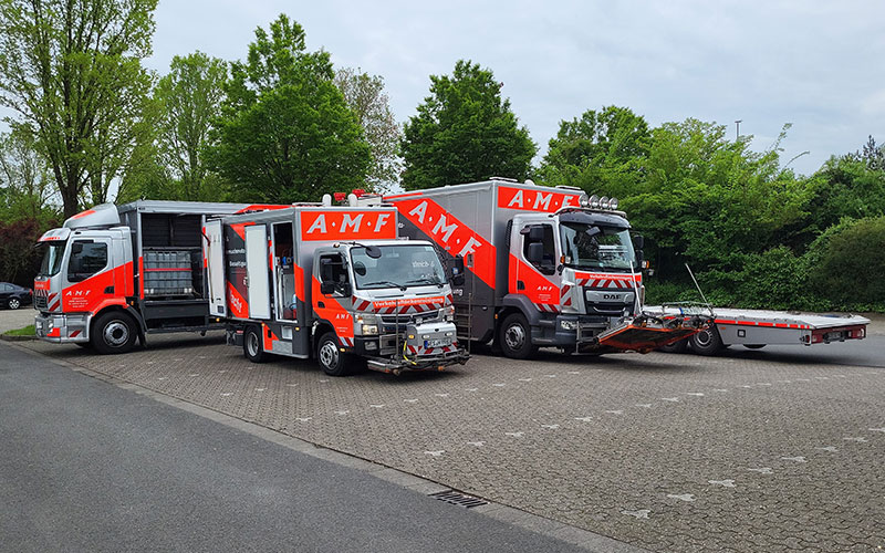 amf-abschleppdienst-verkehrsflaechenreinigung-3 3 Verkehrsflächenreinigungsfahrzeuge von AMF stehen auf einem Parkplatz.